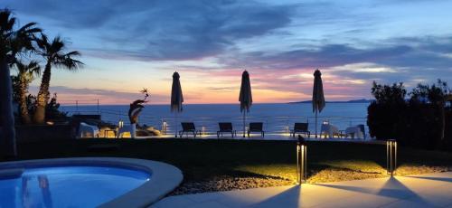 a swimming pool with a view of the ocean at sunset at Villa Bay Blue in Llucmajor