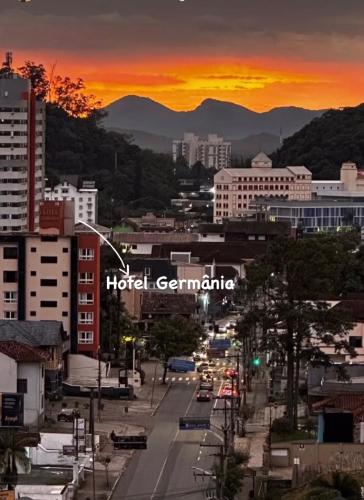 a city street with buildings and a sunset in the background at Hotel Germânia in Joinville