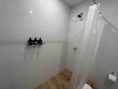 a white bathroom with a shower and a toilet at Dk3-Complete Studio in Zona Viva in Guatemala