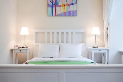 Danylo Inn في إلفيف: غرفة نوم بيضاء بسرير ومصباحين