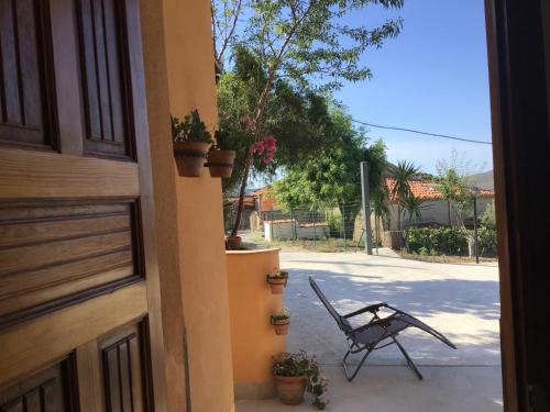 a chair sitting on a porch next to a building at Casa LORE in Castelbuono