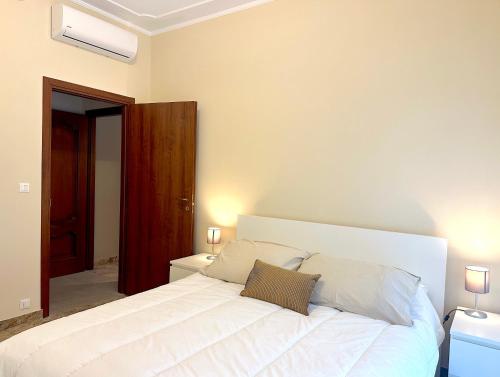 a bedroom with a large white bed with two pillows at Appartamento del Palio in Asti