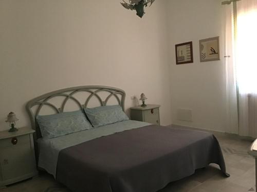 a bedroom with a bed and two tables and a window at Casa LORE in Castelbuono
