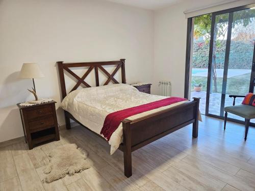 a bedroom with a bed and a chair and a window at Madame Chacras in Chacras de Coria
