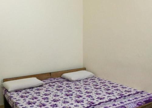 a bed with two pillows on it in a room at GRG Shanti Guest House Varanasi Near Manikarnika Ghat in Varanasi