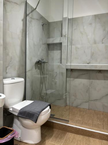 a bathroom with a toilet and a glass shower at Flats 5-11 apts in Heraklio