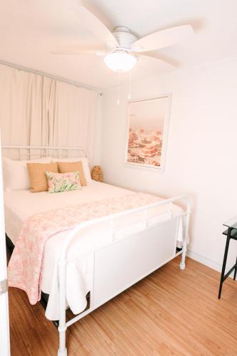 a bedroom with a white bed and a ceiling fan at Beach-Pool-Private Balcony in Tybee Island