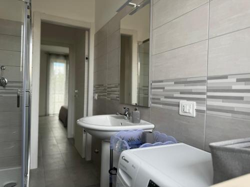 Un baño con lavabo, espejo y bañera. en Residence Riva del Mulino, en Marina di Montenero