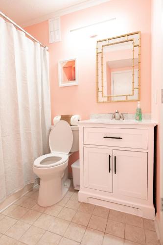 a bathroom with a toilet and a sink and a mirror at Beach-Pool-Private Balcony in Tybee Island