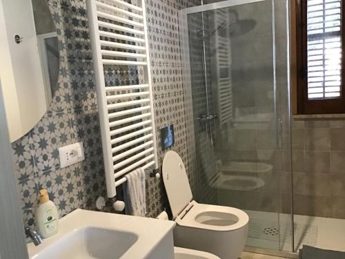 a bathroom with a toilet and a shower and a sink at Casa LORE in Castelbuono
