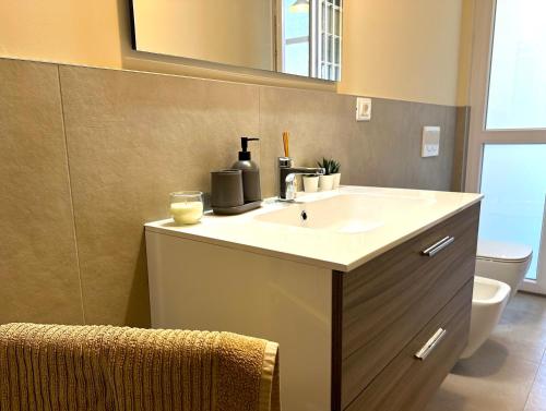 a bathroom with a sink and a mirror and a toilet at Appartamento del Palio in Asti