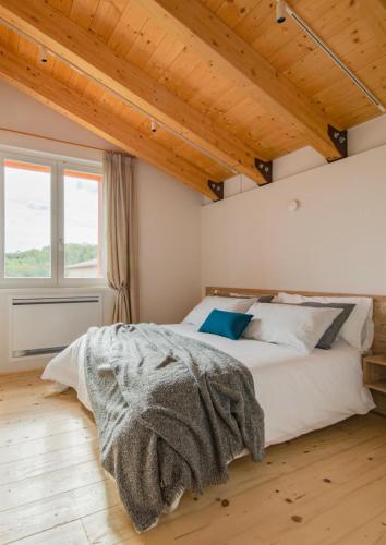 ein Schlafzimmer mit einem großen Bett in einem Zimmer mit Holzdecke in der Unterkunft Tenuta Grimaldi Wine Resort in Matelica