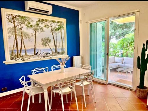 a dining room with a white table and chairs at Casa Marchese in Tirrenia