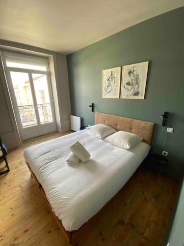 un grand lit blanc dans une chambre avec une fenêtre dans l'établissement Terra Élégant appartement Gare SNCF 4p, à Clermont-Ferrand