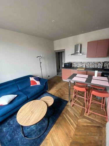 un salon avec un canapé bleu et une table dans l'établissement Terra Élégant appartement Gare SNCF 4p, à Clermont-Ferrand