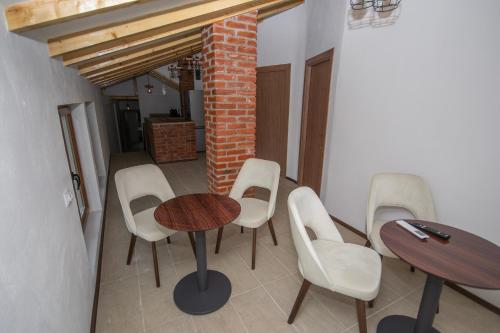 a room with a table and chairs and a brick wall at Arаbeska Family Winery & Apartments in Kavadarci