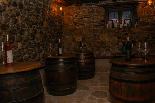 a bar with wooden barrels and bottles of wine at Arаbeska Family Winery & Apartments in Kavadarci