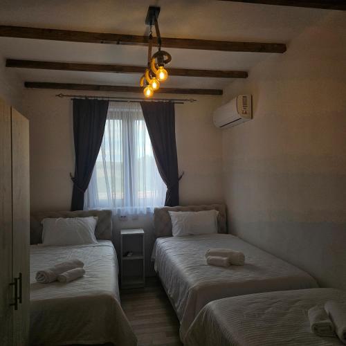 two beds in a room with a window at Arаbeska Family Winery & Apartments in Kavadarci