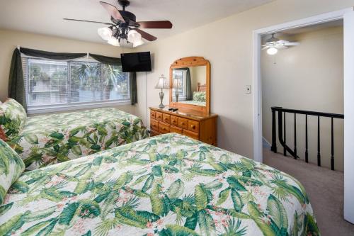een slaapkamer met een bed, een dressoir en een spiegel bij Seaspray Condos 210B in Fort Walton Beach