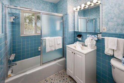een blauw betegelde badkamer met een douche en een wastafel bij Seaspray Condos 210B in Fort Walton Beach