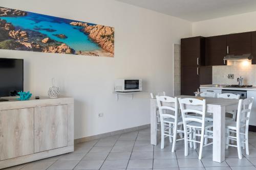 a kitchen with a table and chairs in a room at Appartamenti Le Vele in La Maddalena
