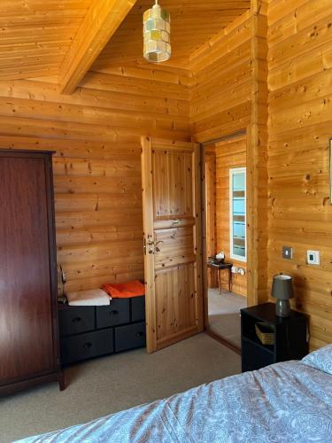una camera con un letto in una baita di tronchi di Holme Woodmans Lodge a Holme