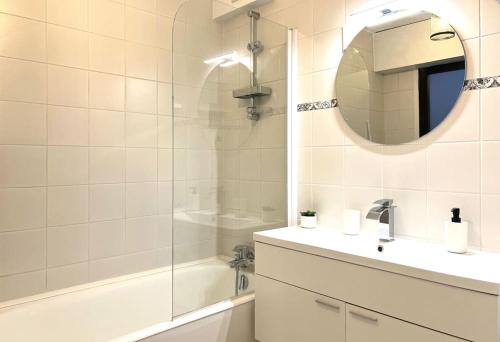une salle de bain avec un lavabo, un miroir et une baignoire dans l'établissement Spacieux duplex parisien rénové, proche Tour Eiffel, à Paris