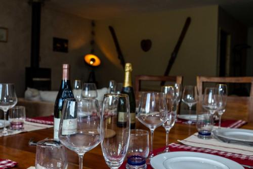 a wooden table with glasses and bottles of wine at Le Galussel Gite d'étape et de séjour in Saint-Sébastien