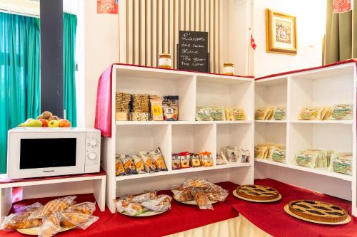 a kitchen with a microwave and some food on shelves at Hotel Lungomare in Cervia
