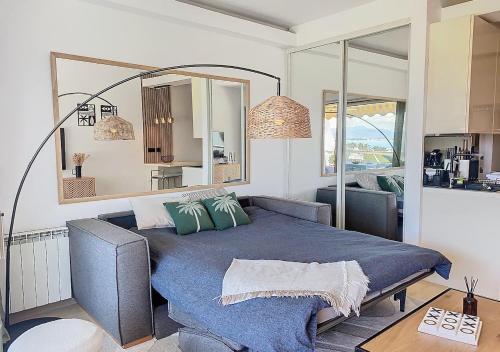 une chambre avec un grand lit avec une couverture bleue dans l'établissement T1bis vue mer et port Marina Baie des Anges, à Villeneuve-Loubet