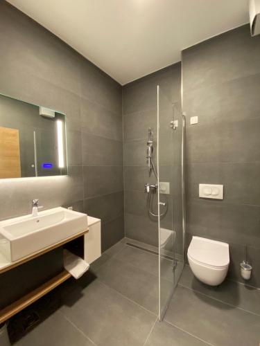 a bathroom with a sink and a toilet and a shower at Hotel Leonardo in Slovenska Bistrica