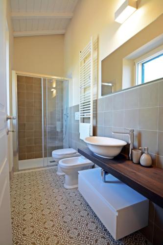a bathroom with three toilets and a sink and a shower at Maremma 1851 in Follonica