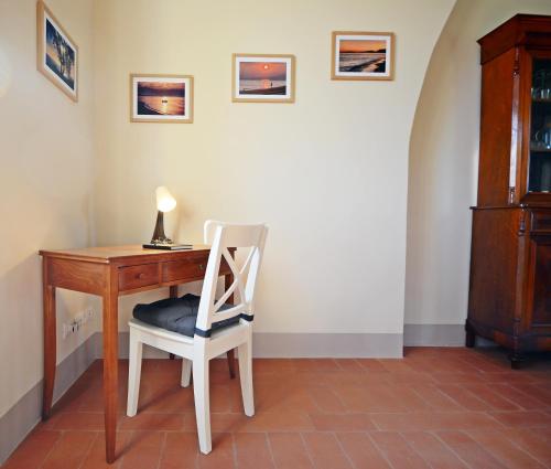 a desk with a chair next to a table with a lamp at Maremma 1851 in Follonica