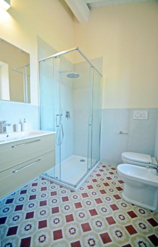 a bathroom with a glass shower and a toilet at Maremma 1851 in Follonica