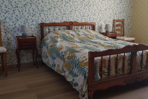 a bedroom with a bed with a comforter and two night stands at Le Mimosa, maison de vacances in Trans-la-Forêt