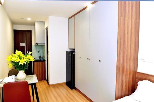 a room with a bed and a table and a kitchen at Era Apartment Trung Liet in Hanoi