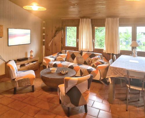 ein Wohnzimmer mit einem Sofa und einem Tisch in der Unterkunft Maison de 3 chambres avec jardin clos et wifi a Vendays Montalivet a 7 km de la plage in Vendays-Montalivet