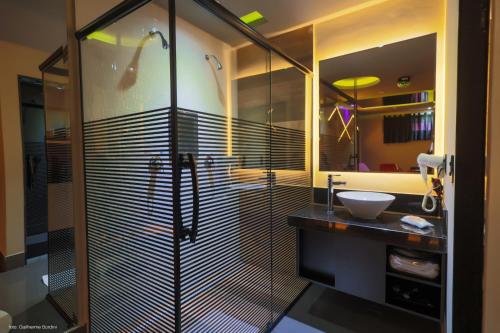 a bathroom with a glass shower and a sink at Prestige Motel 2 in Curitiba