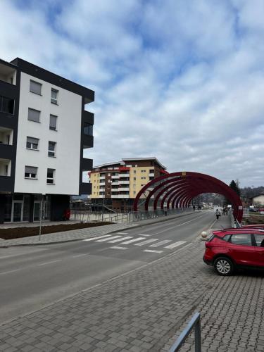 a red car parked on the side of a road at Apartman Nora in Teslić