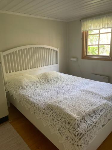 a white bed in a bedroom with a window at Yngsjö, Aspvägen in Yngsjö