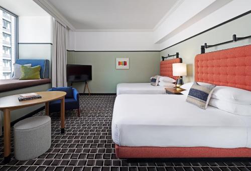 una camera d'albergo con 2 letti e una scrivania di L7 Chicago by LOTTE a Chicago