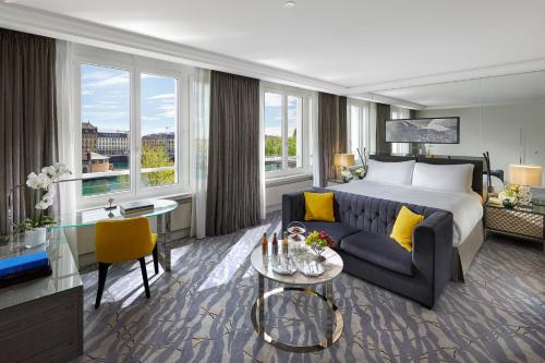 a hotel room with a bed and a couch at Mandarin Oriental, Geneva in Geneva