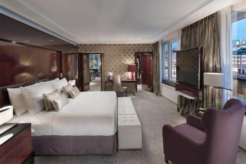 a bedroom with a large bed and a living room at Mandarin Oriental, Geneva in Geneva