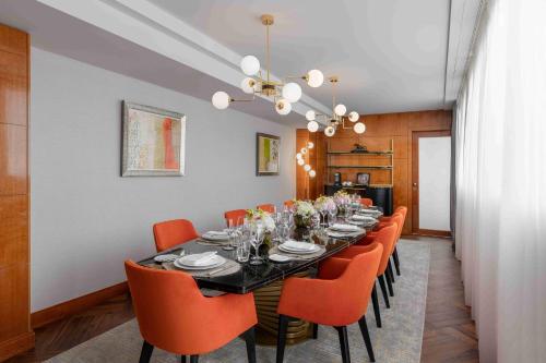 a dining room with a black table and orange chairs at Mandarin Oriental, Geneva in Geneva