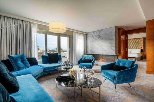 a living room with blue couches and a fireplace at Mandarin Oriental, Geneva in Geneva