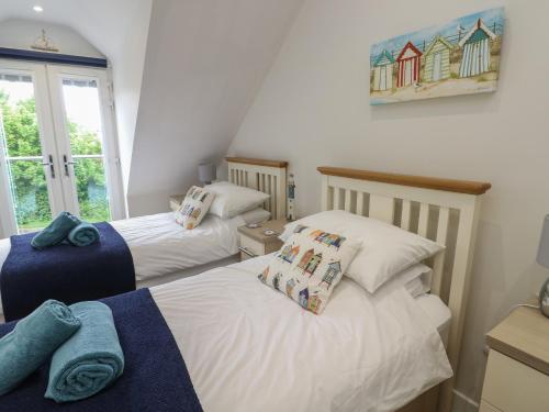a bedroom with two beds and a window at Sandy Bay Retreat in Benllech