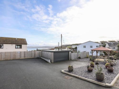a backyard with potted plants and a fence at Sandy Bay Retreat in Benllech