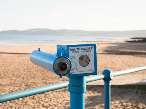 a blue pole with a camera on the beach at Sandy Bay Retreat in Benllech