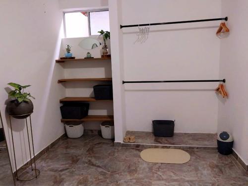 una habitación con una escalera con estanterías y un suelo en Habitación Cómoda en Familia, en Ibagué