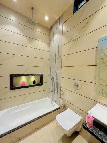 a bathroom with a tub and a toilet and a sink at The Breeze Valley in Mahabaleshwar